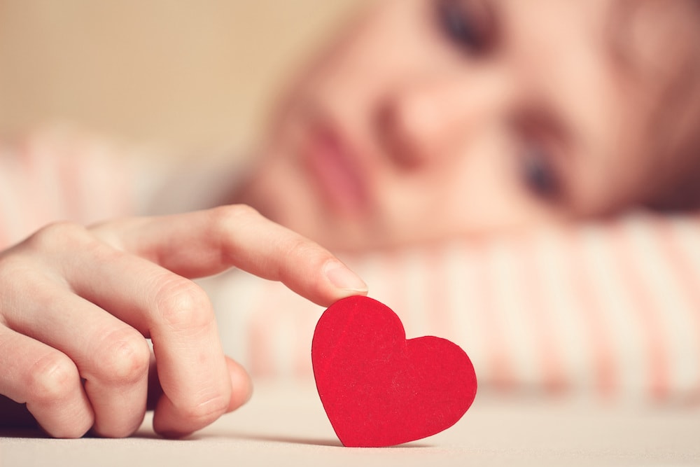 Someone looking unhappy playing with a loveheart