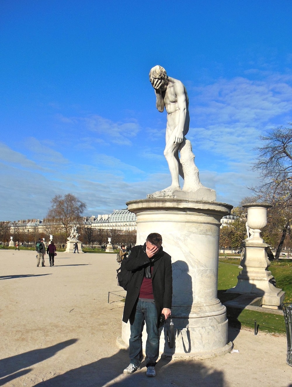 Phil with a statue making a similar pose of his head in his hands