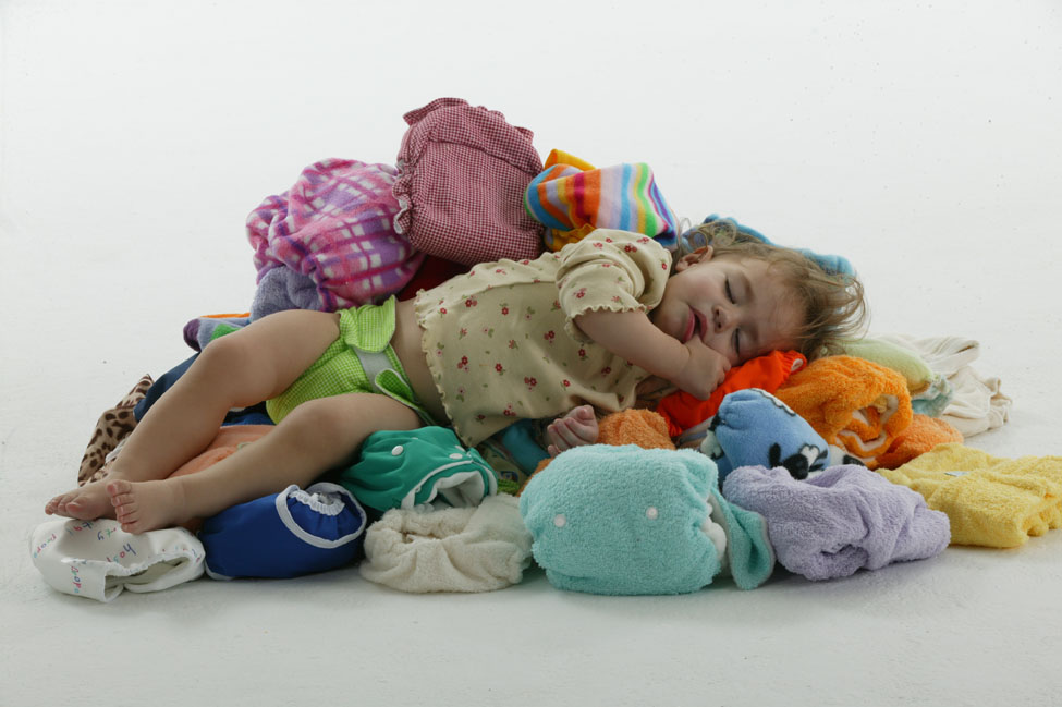 A baby sitting on a pile of disposable nappies