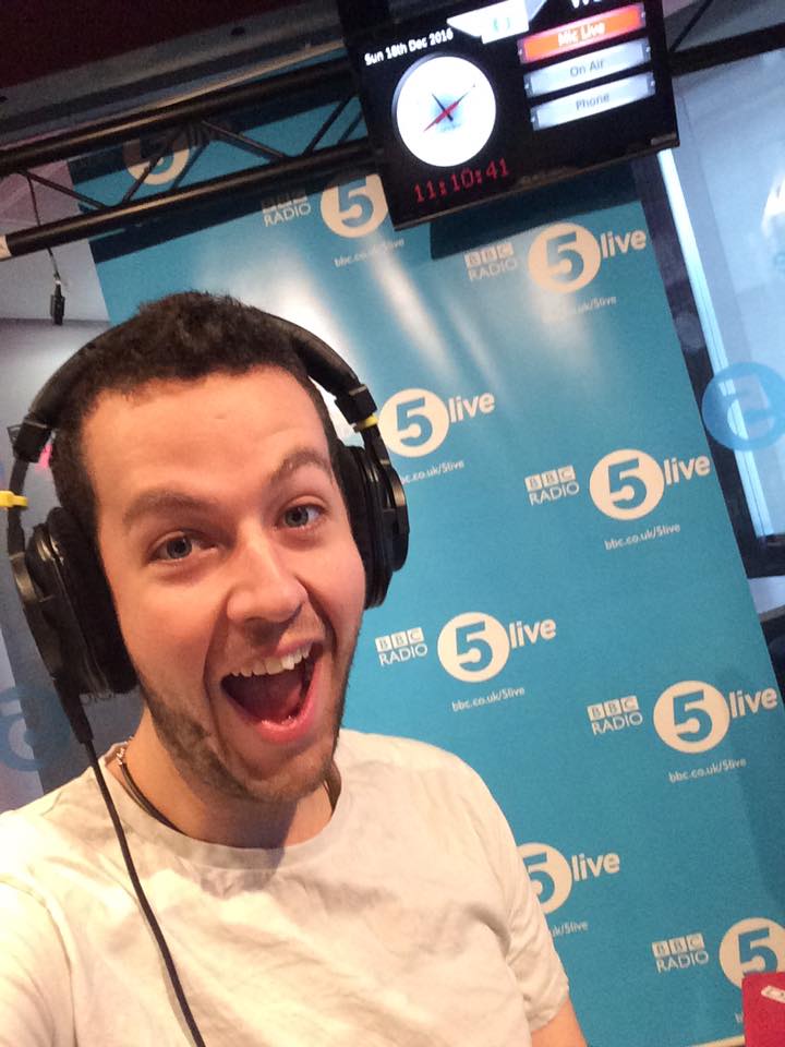 This is photo of Dave psmiling excited behind the scenes of a radio show
