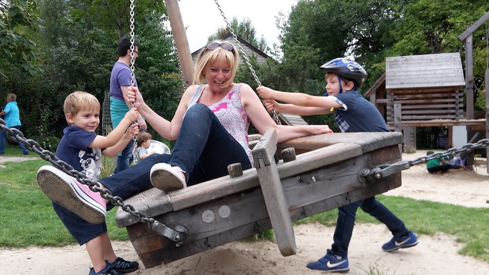 This is photo of Debra playing in a park playground with her sons