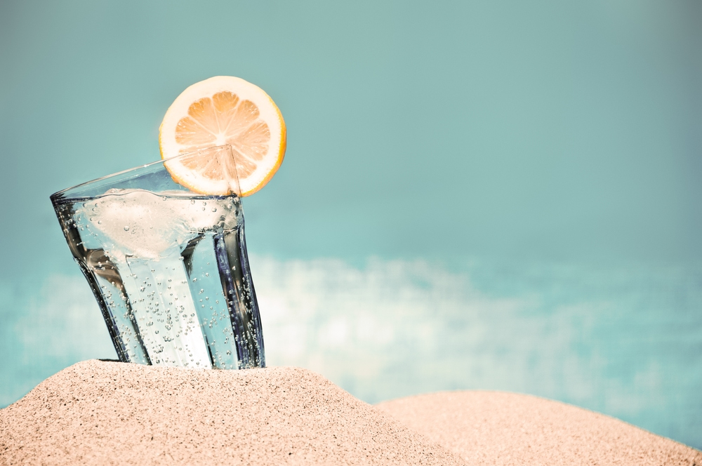 This is a photo of a glass of iced water on the beach