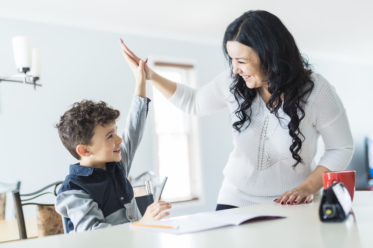 A mouth and young son high-five over his homework