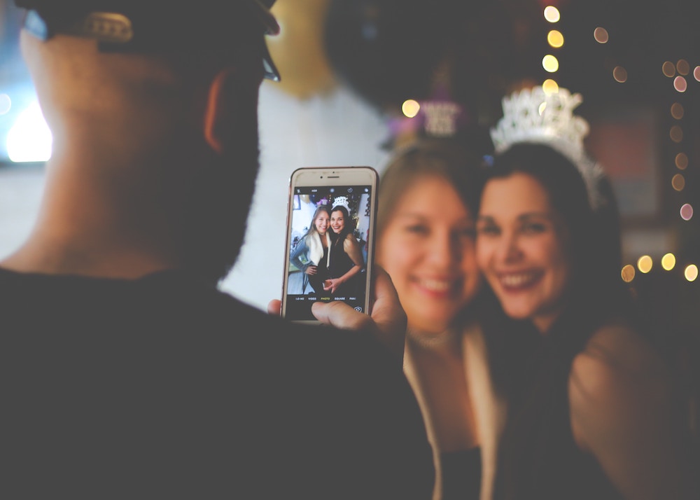 man taking photo of women at party