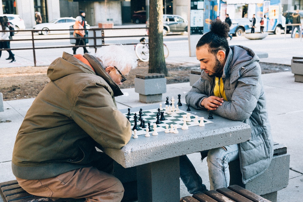 old man and young man playing chess