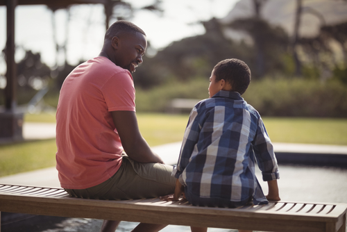 Father and son talking together outside