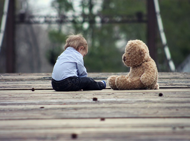 child-plays-alone-with-teddy-bear
