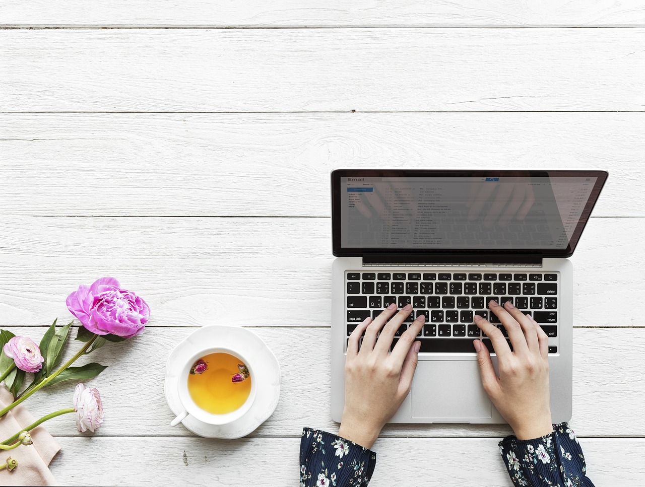 woman-writes-using-laptop-with-tea