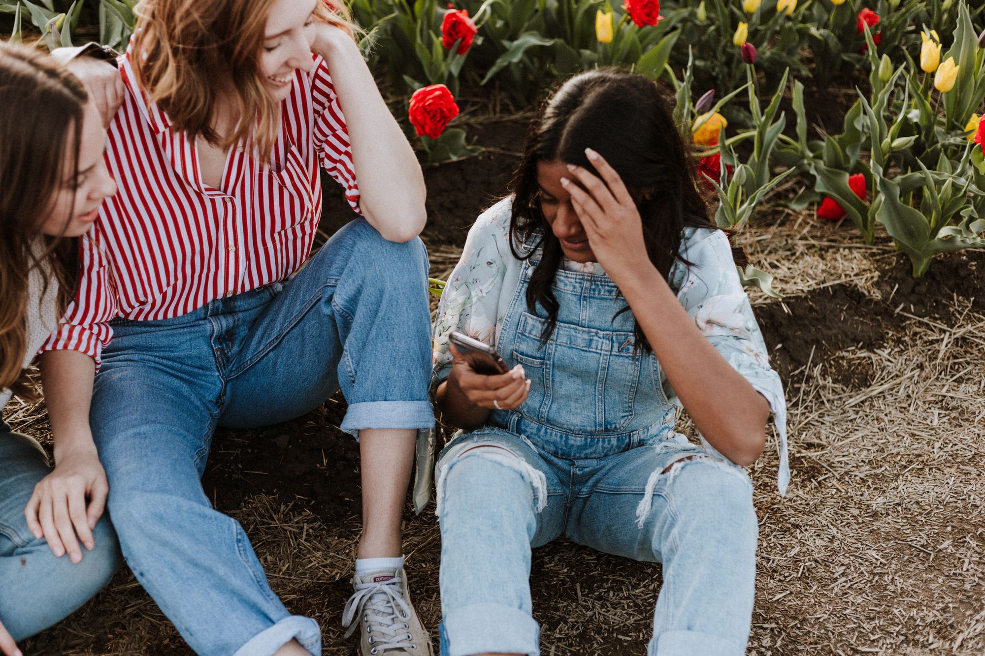 Young girls sat together with a backdrop of tulips