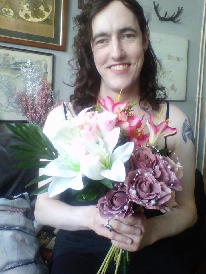 Morgana holding a bouquetof flowers and smiling