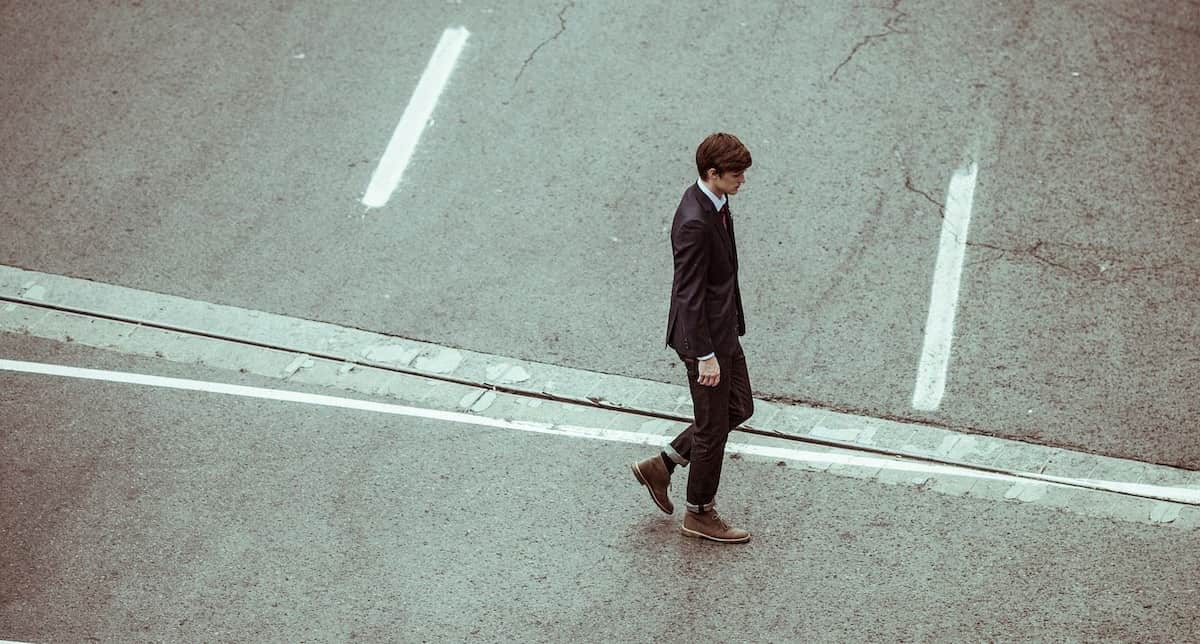 Lonely man walking across street