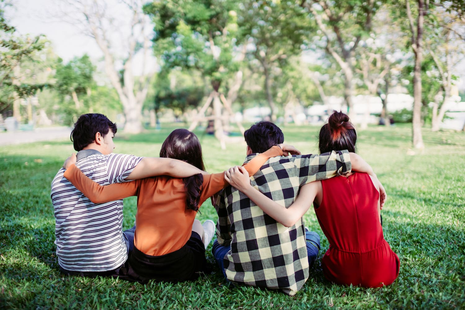 Four friends sat with their arms around each other