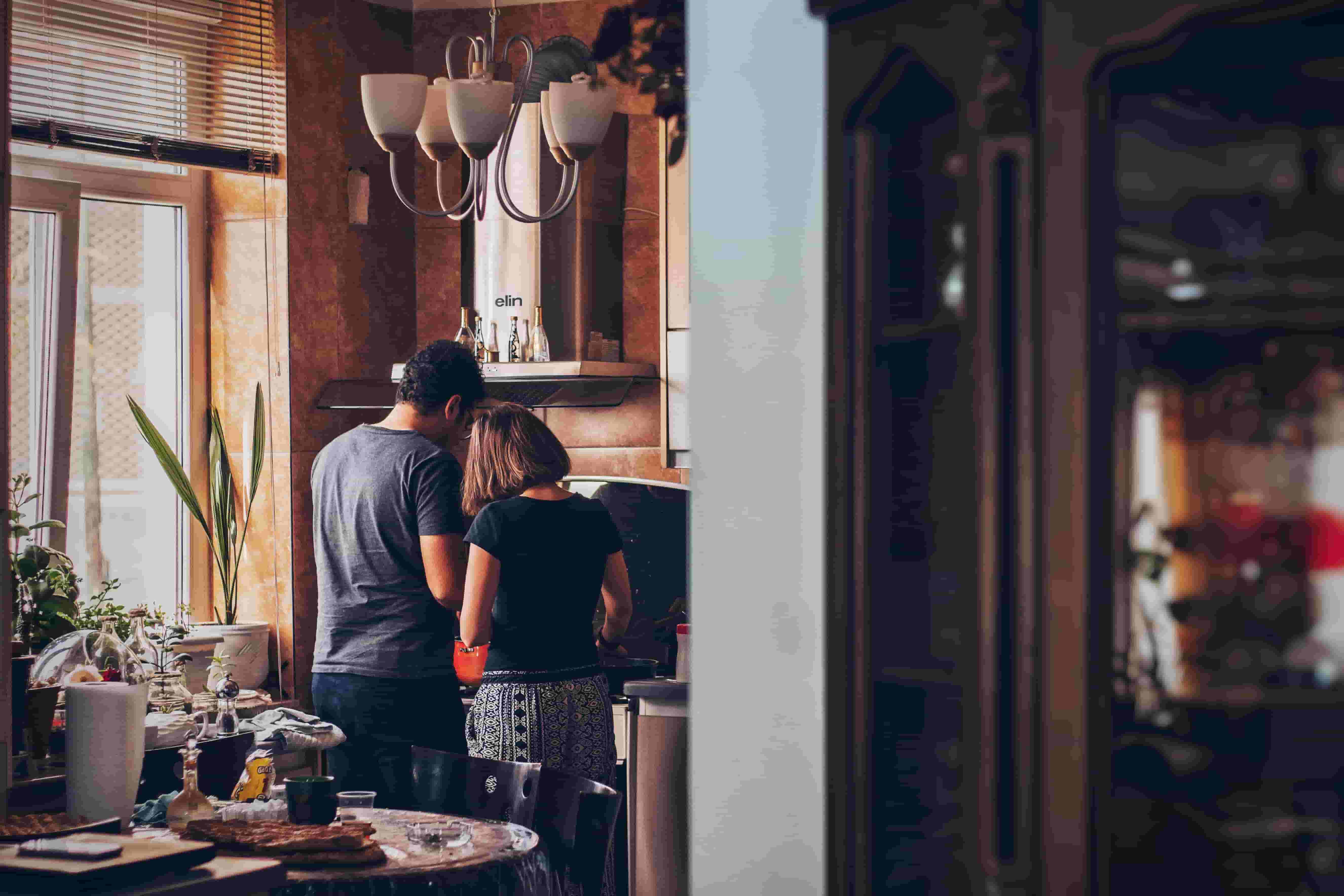 A couple talk, as they cook dinner together