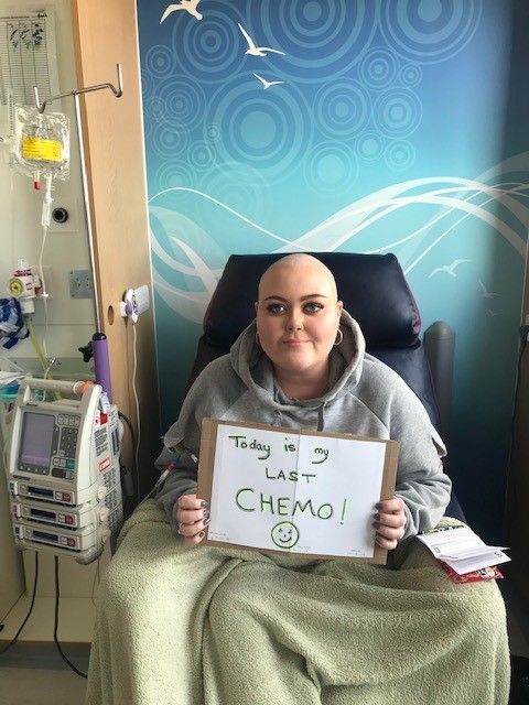 A photo of Alice smiling in hospital on her last day of chemotherapy