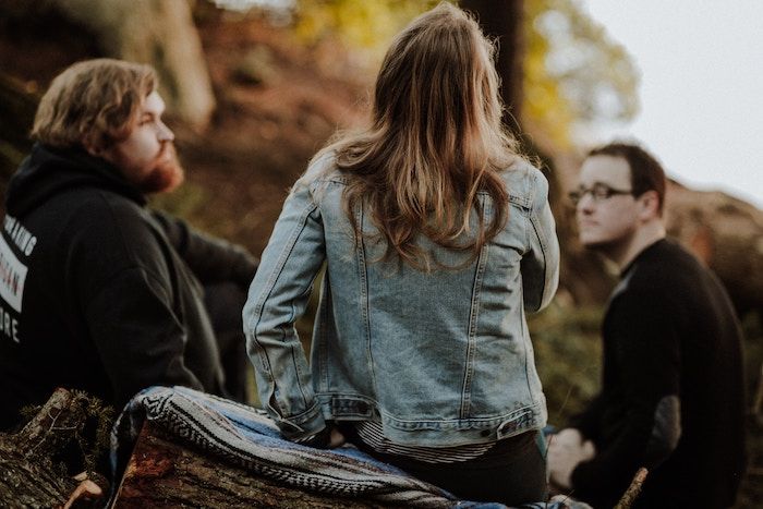 Image of three young adults talking to each outside in Autumn.