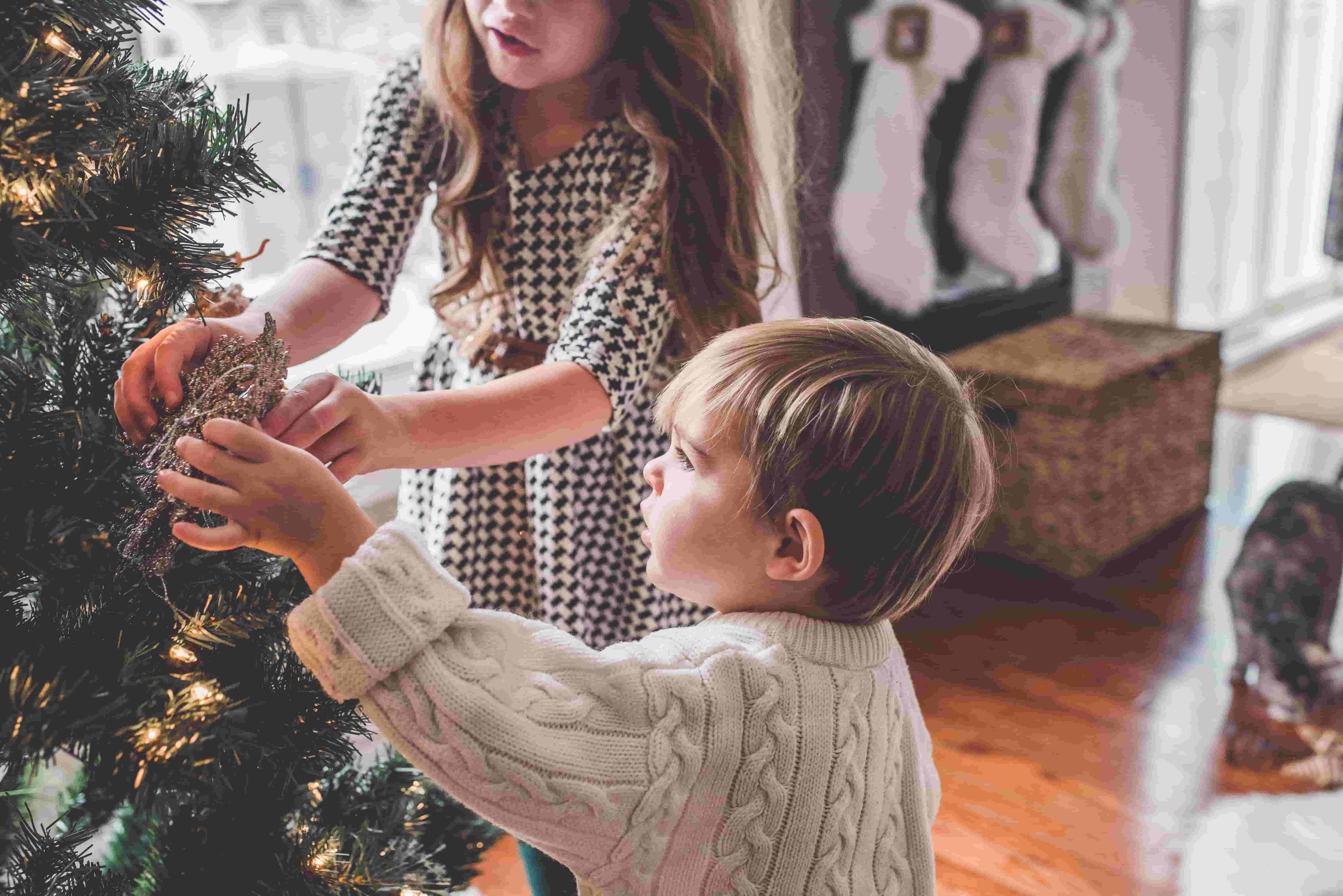 Two children decorate a Christmas tree together