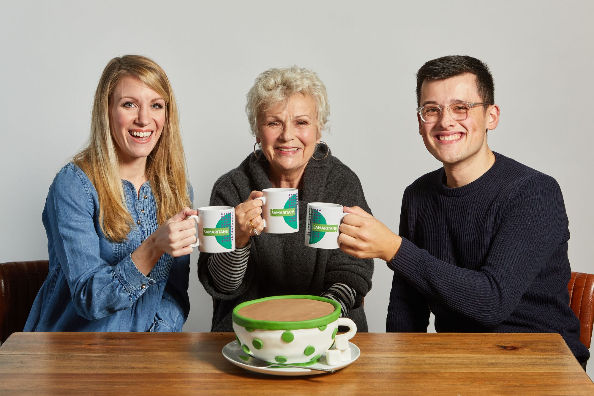 Dame Julie, Rachel and Michael share a cup of tea and pose with a teacup-shaped cake
