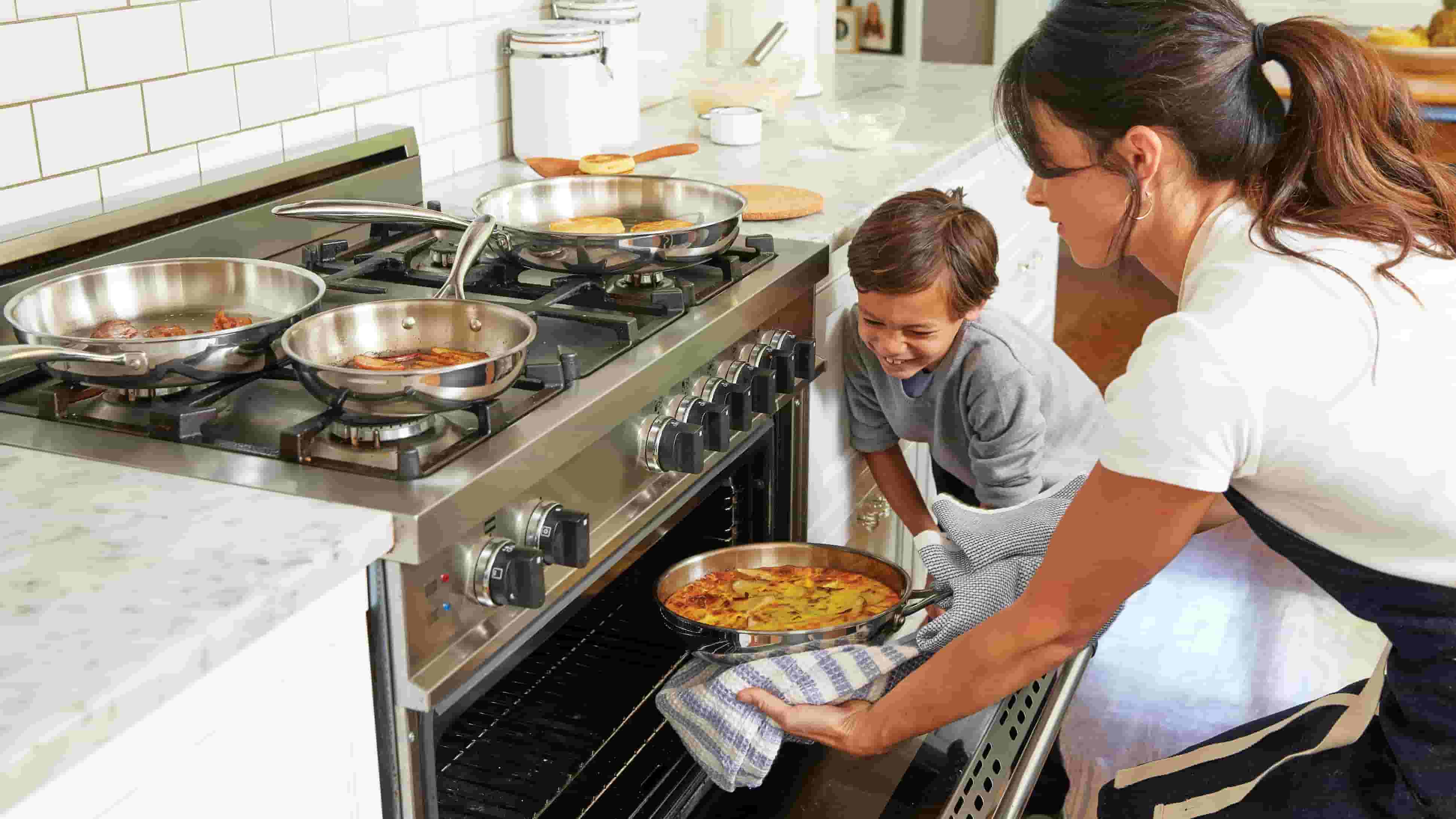 A young boy helps his mother cooking
