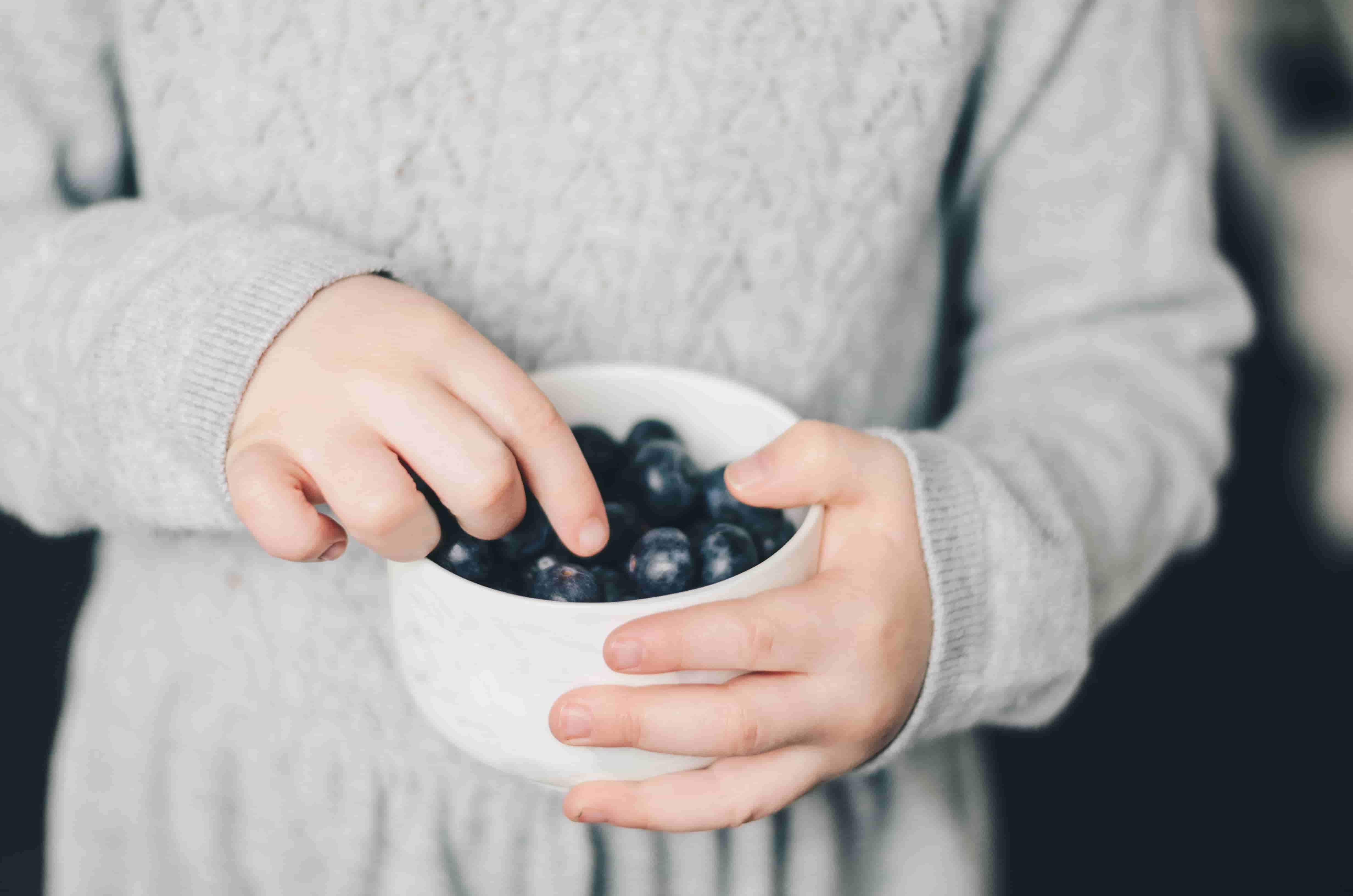 Close-up of a child eating blueberries