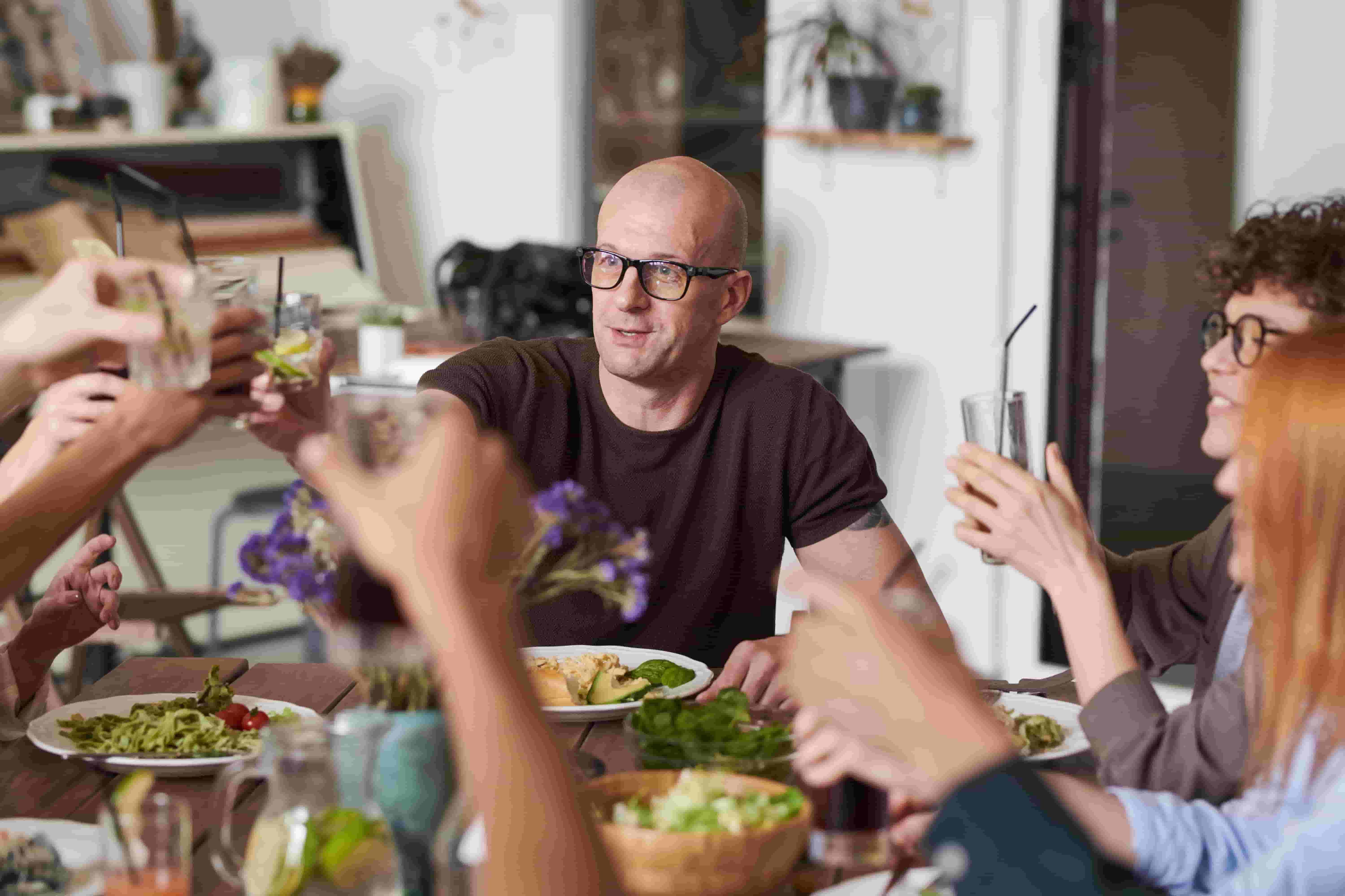 A family share dinner together, smiling and having a good time