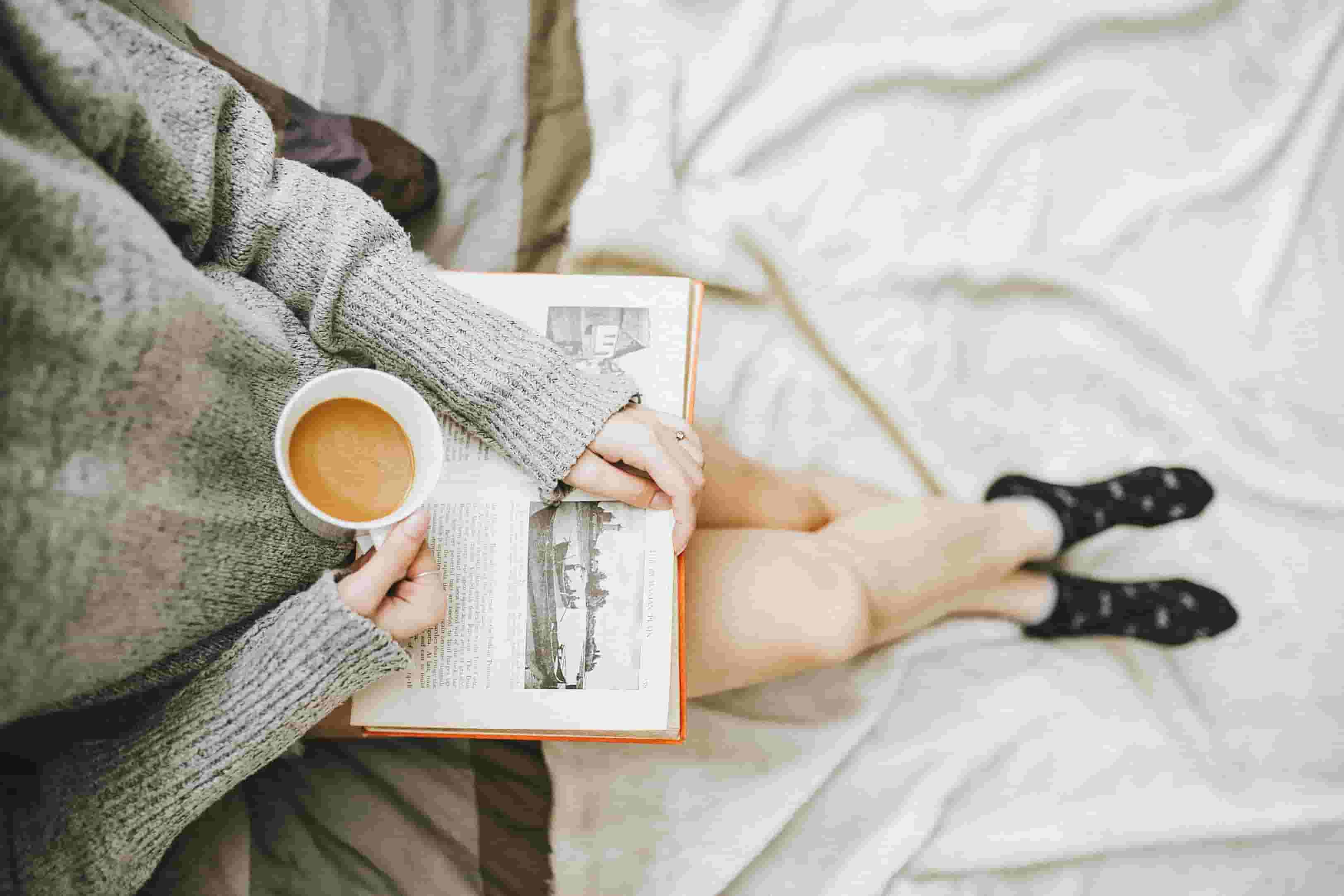 A woman drinks tea and reads