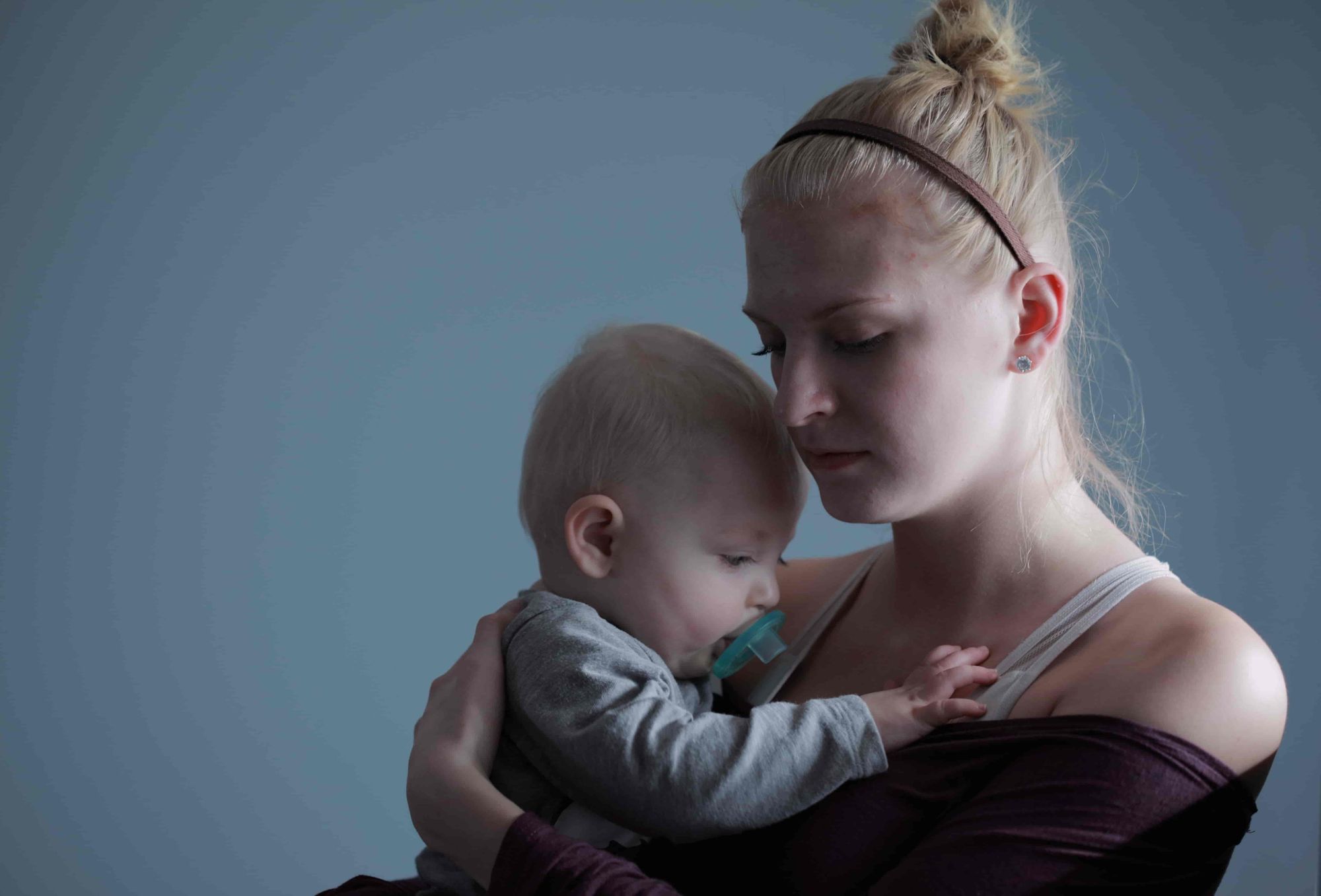 An exhausted mum holds her baby