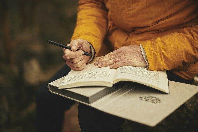 Close-up of someone writing in their journal