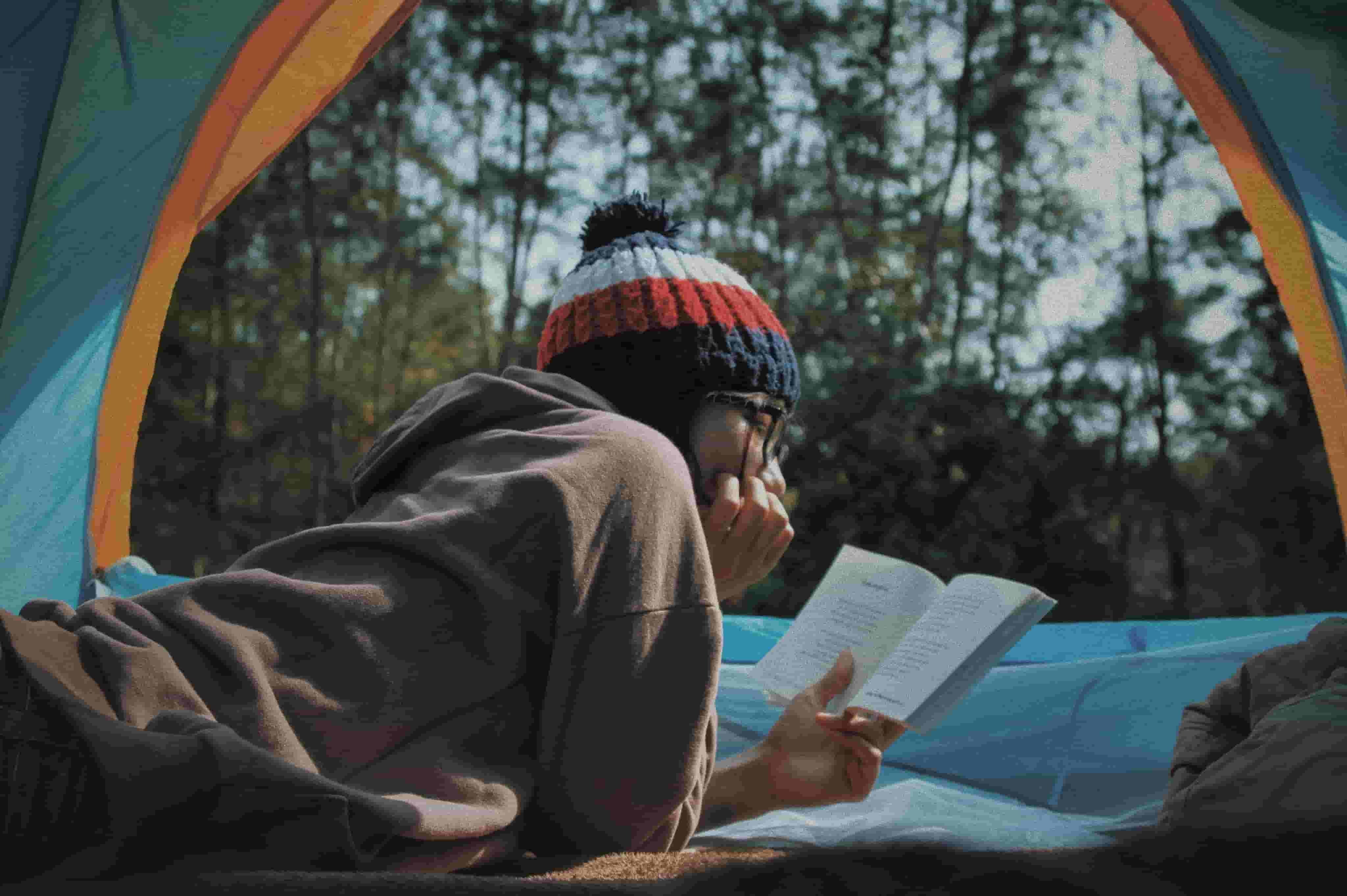 A woman reads whilst camping