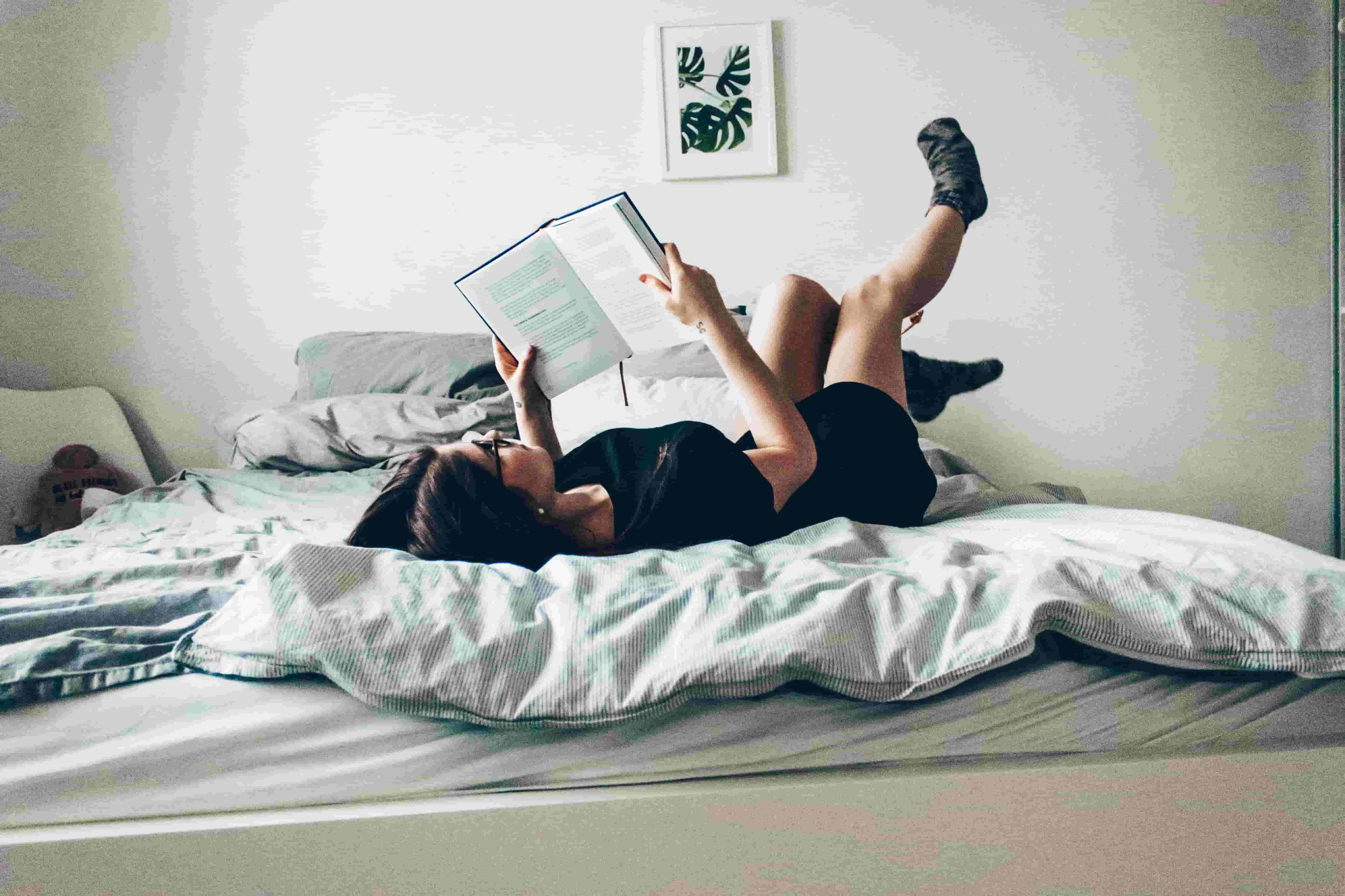 A woman lays in bed reading