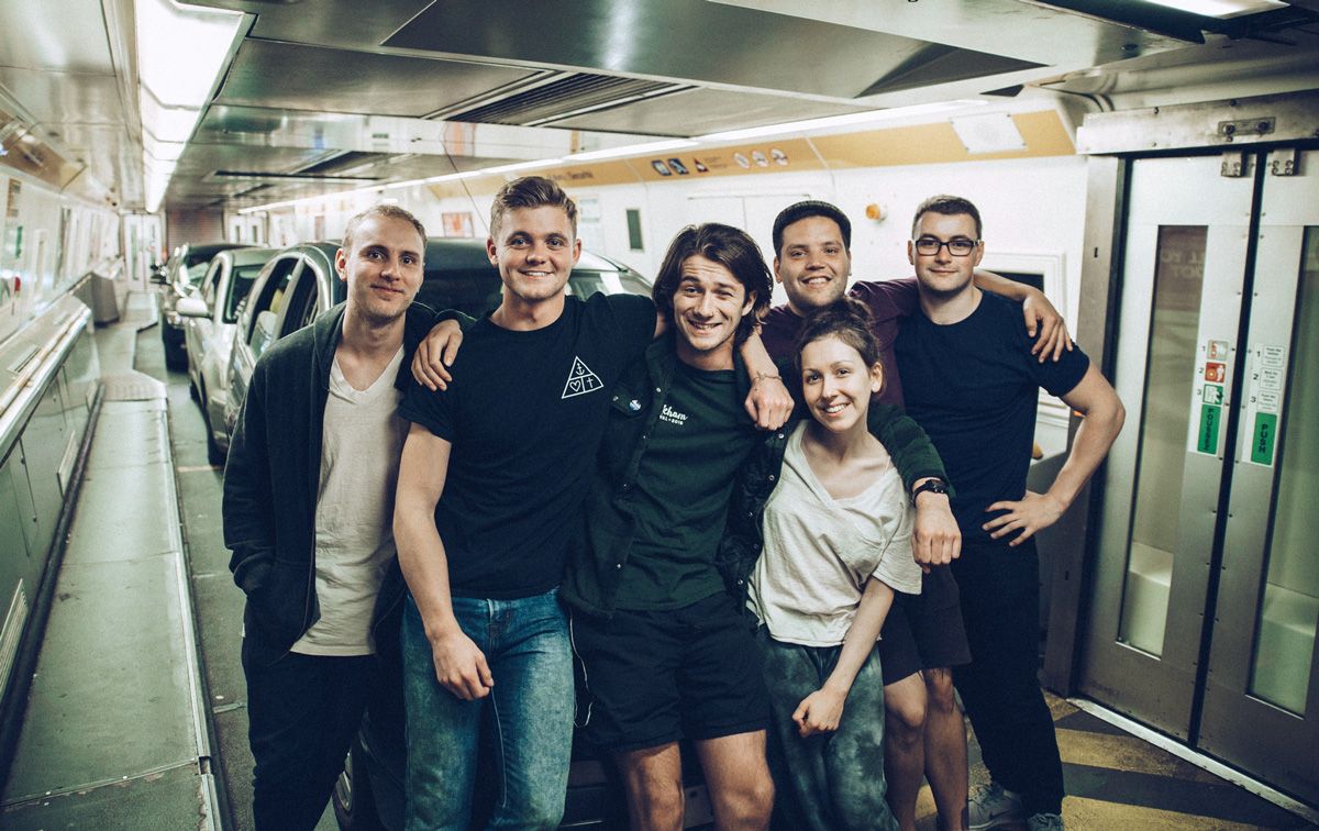 A picture of a group of friends on the Eurostar, they are smiling towards the camera