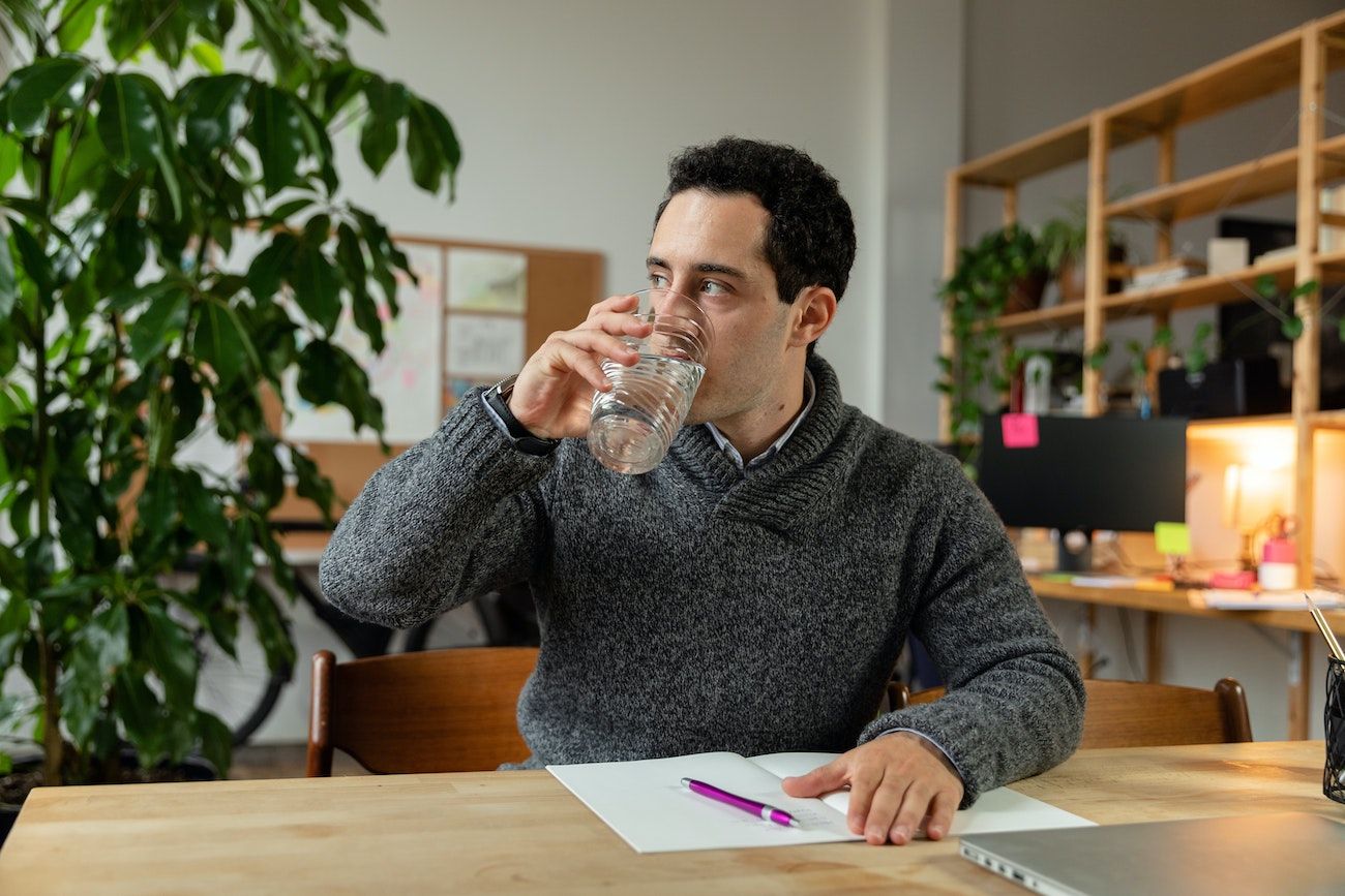 Man drinking water at desk