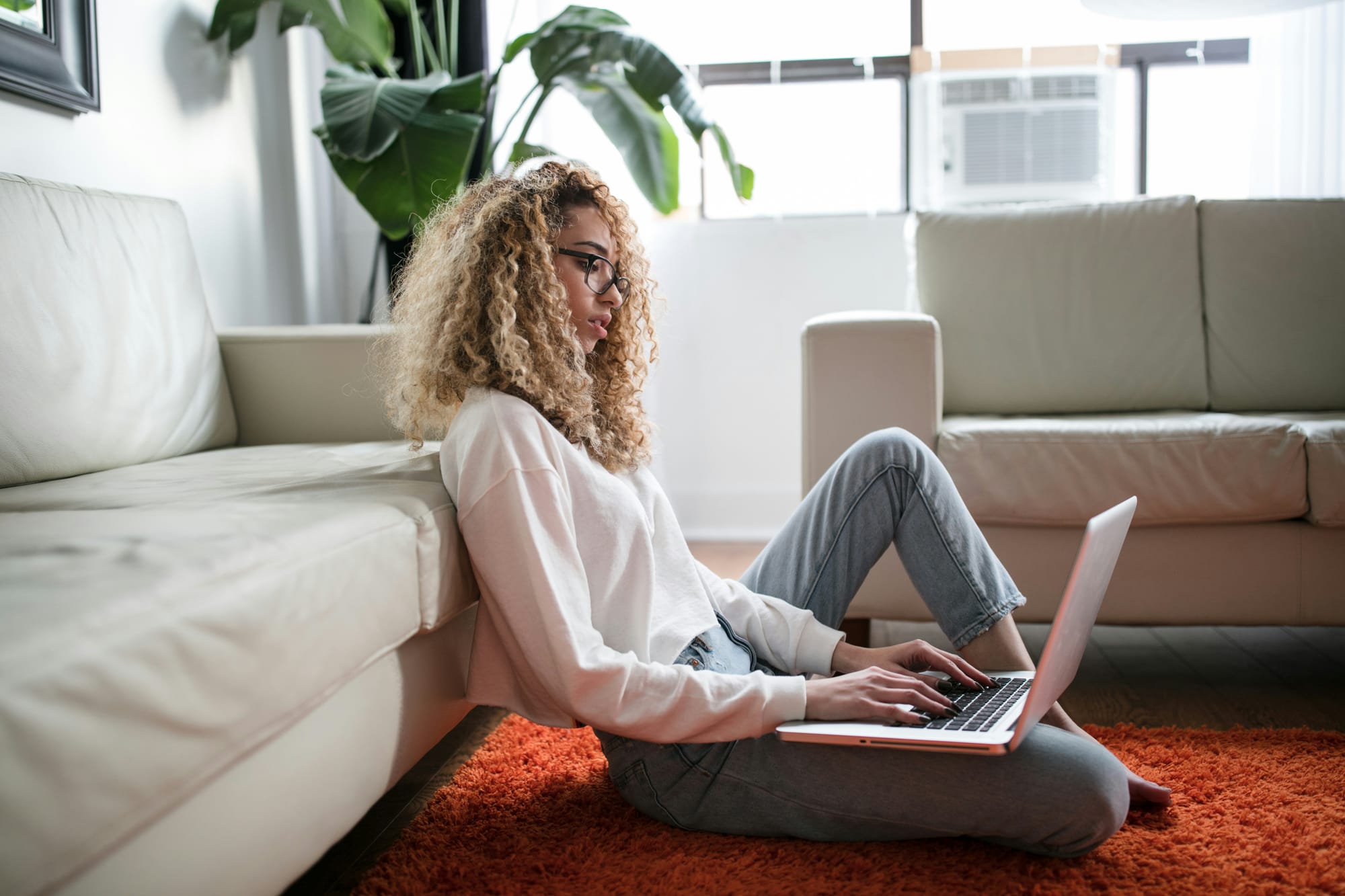 woman-sits-on-the-floor-working-on-a-laptop.jpg